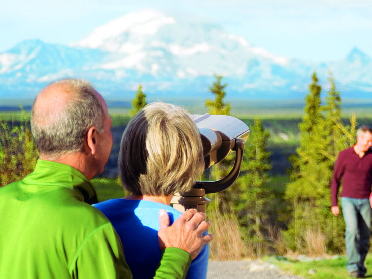 A couple enjoys the vista of the Wrangell Mountains while on a cruise to Alaska.