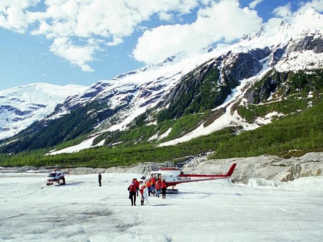 Cruise passengers walking on a glacier in Alaska on a helicopter tour.